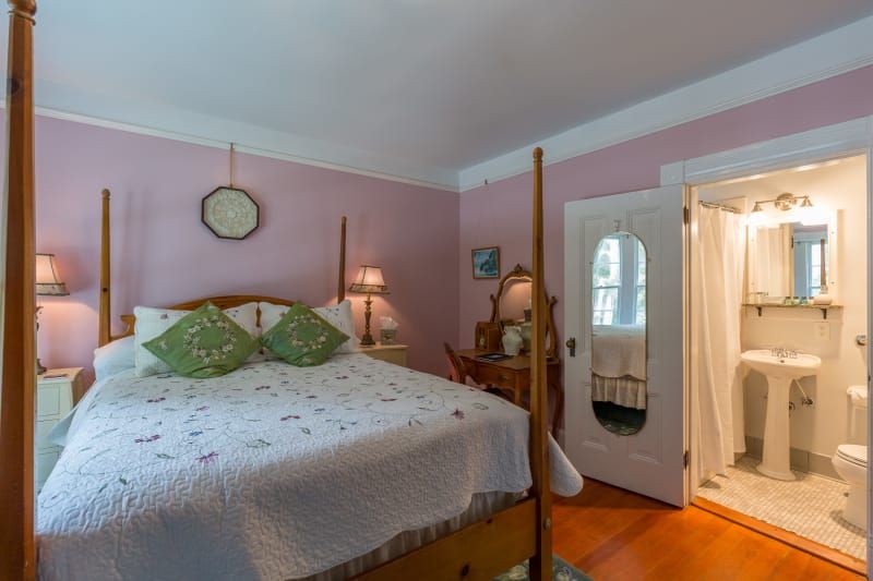 A bedroom with a four poster bed and a bathroom.