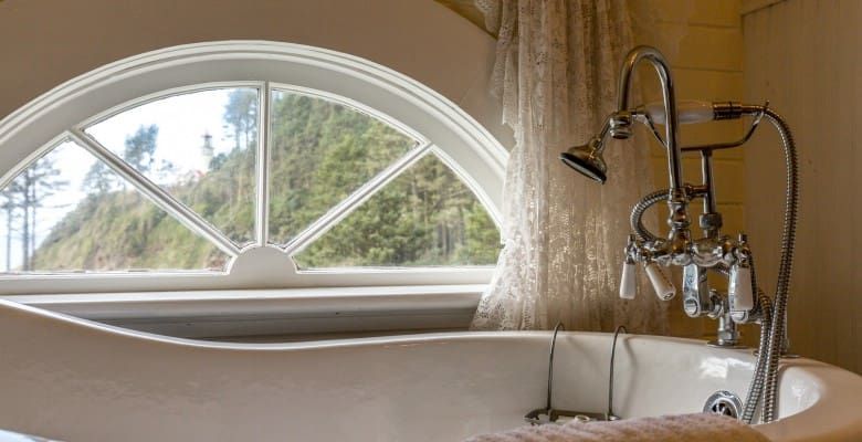 A bathtub is sitting in front of a window in a bathroom.