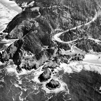 An aerial view of a rocky coastline with a road going through it.