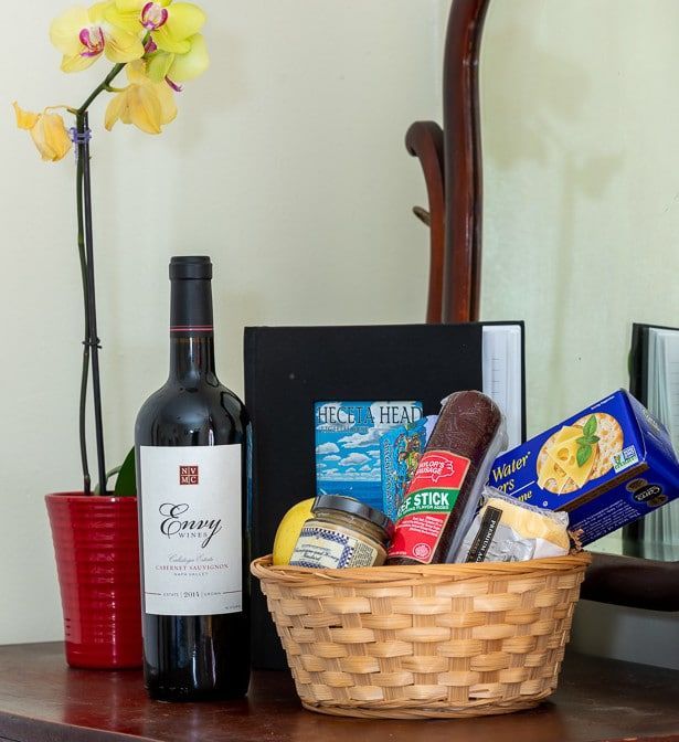 A bottle of envy wine sits next to a basket of food