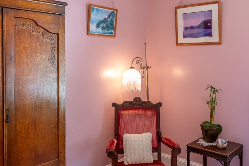 A room with pink walls and a red chair
