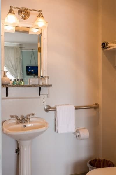 A bathroom with a sink a toilet and a mirror