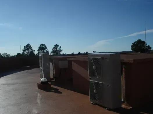 Azotea con dos unidades de climatización plateadas bajo un cielo azul despejado.