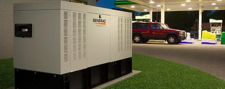 A large generator next to a gas station with a red SUV.