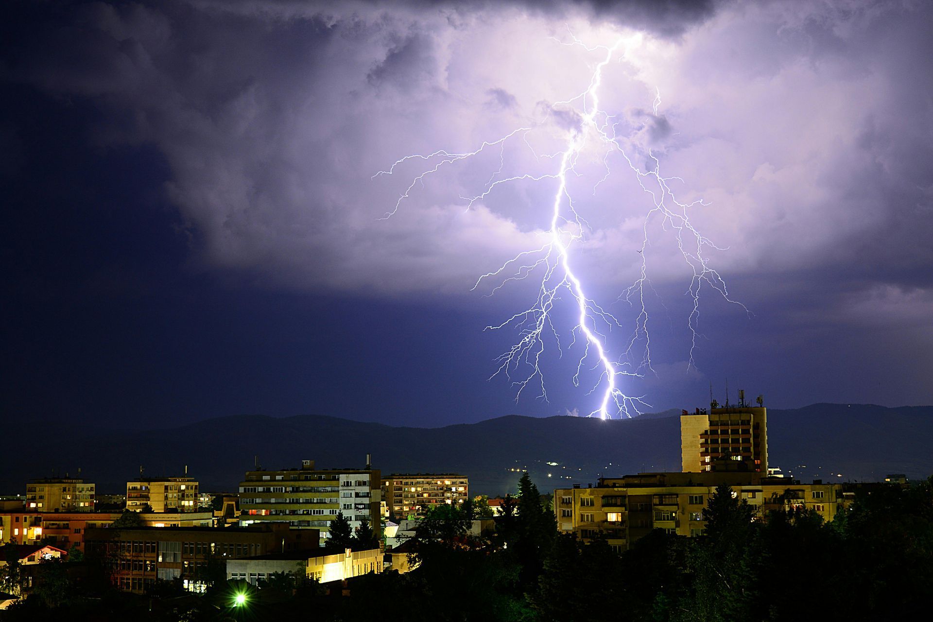 Lightning strikes a city skyline at night.
