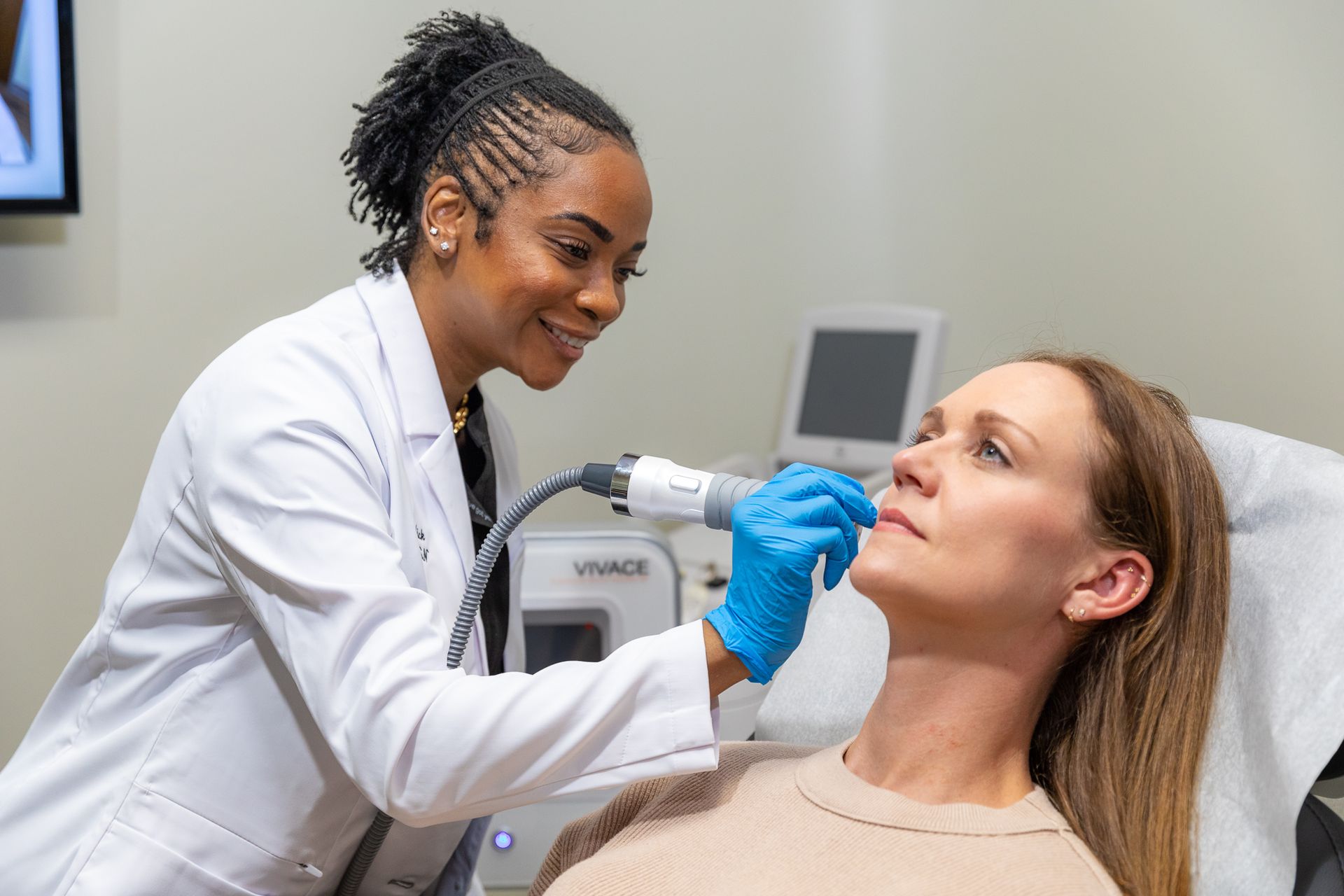 A woman is getting a facial treatment from a doctor.