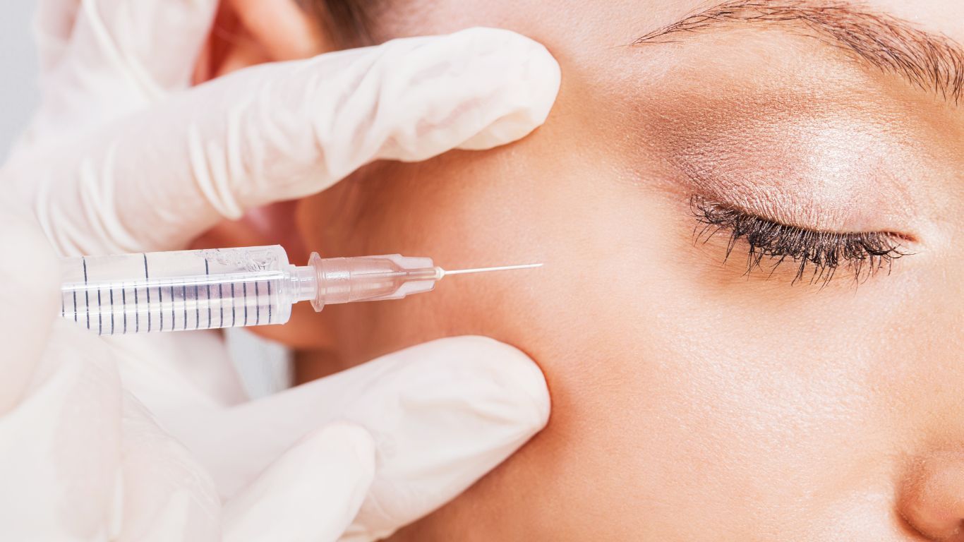 A woman is getting a botox injection in her face.
