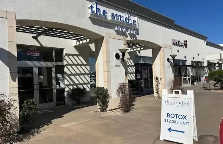 exterior photo of the studio med spa advertising Botox at $12.00 per unit with a left arrow pointing toward the entrance