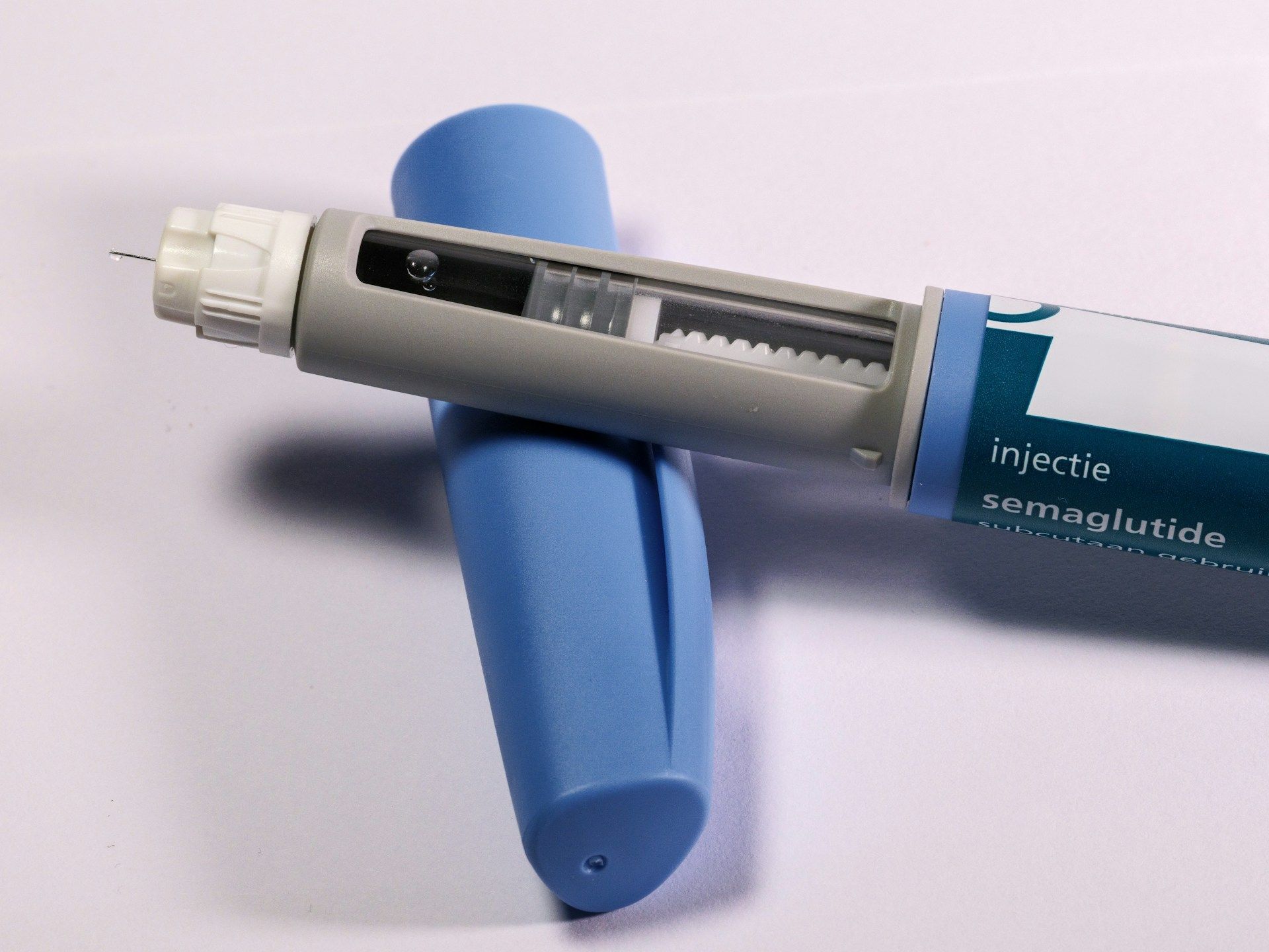 Blue and gray insulin pen lying on a blue case, with dosage window visible