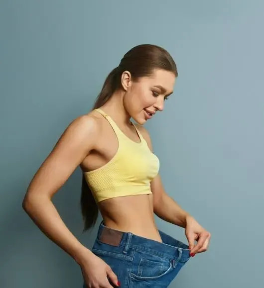 women checking pant size after loosing weight following skinny shots treatment