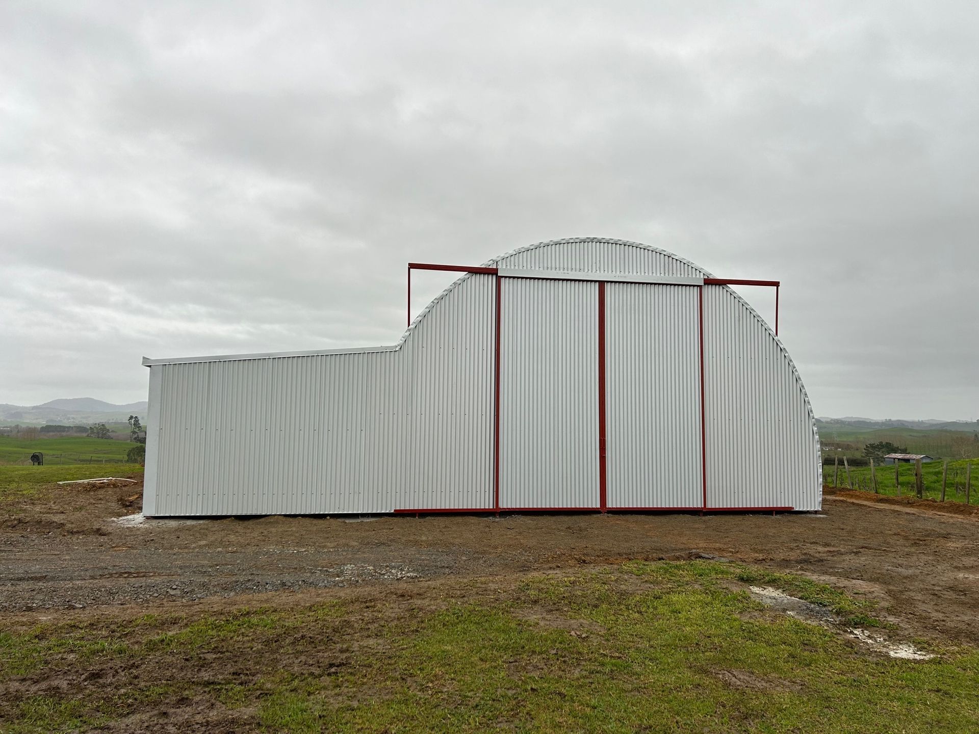 A large building with a curved roof and a white door