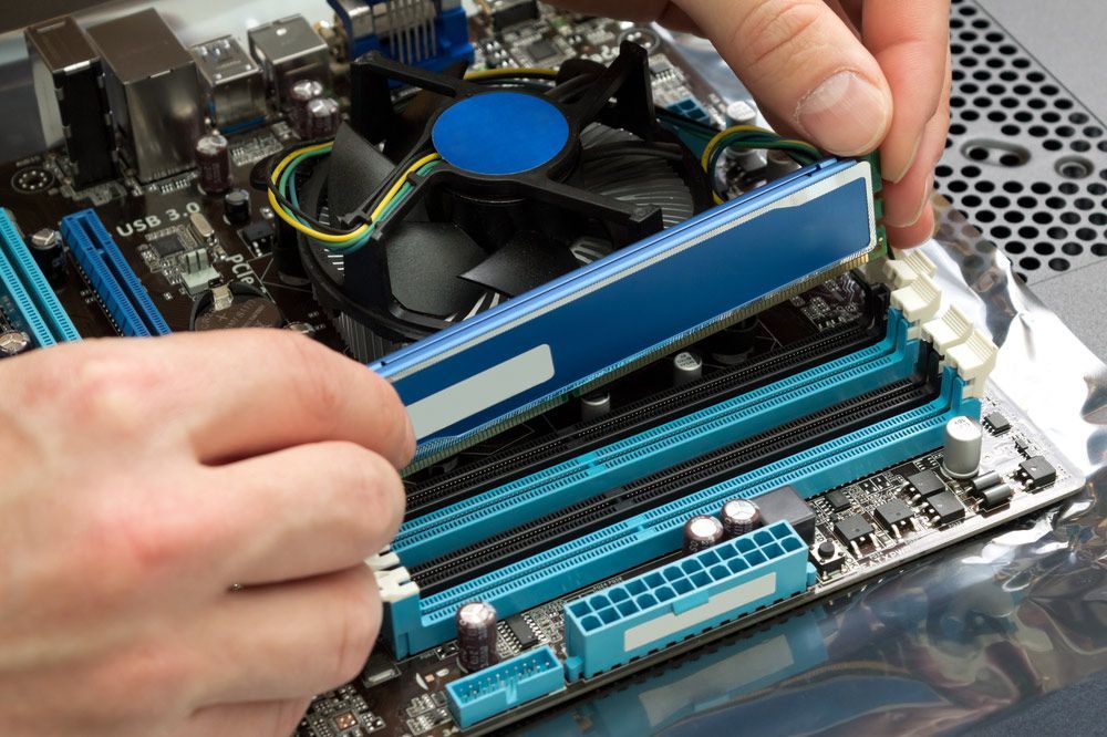 A Person Is Installing A Ram Stick On A Motherboard — Lismore Computer Solutions In Lismore, NSW