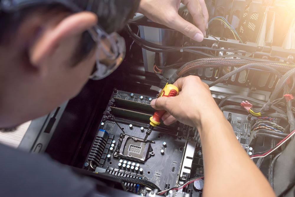 A Man is Working on a Computer Motherboard With a Screwdriver — Lismore Computer Solutions in Kyogle, NSW