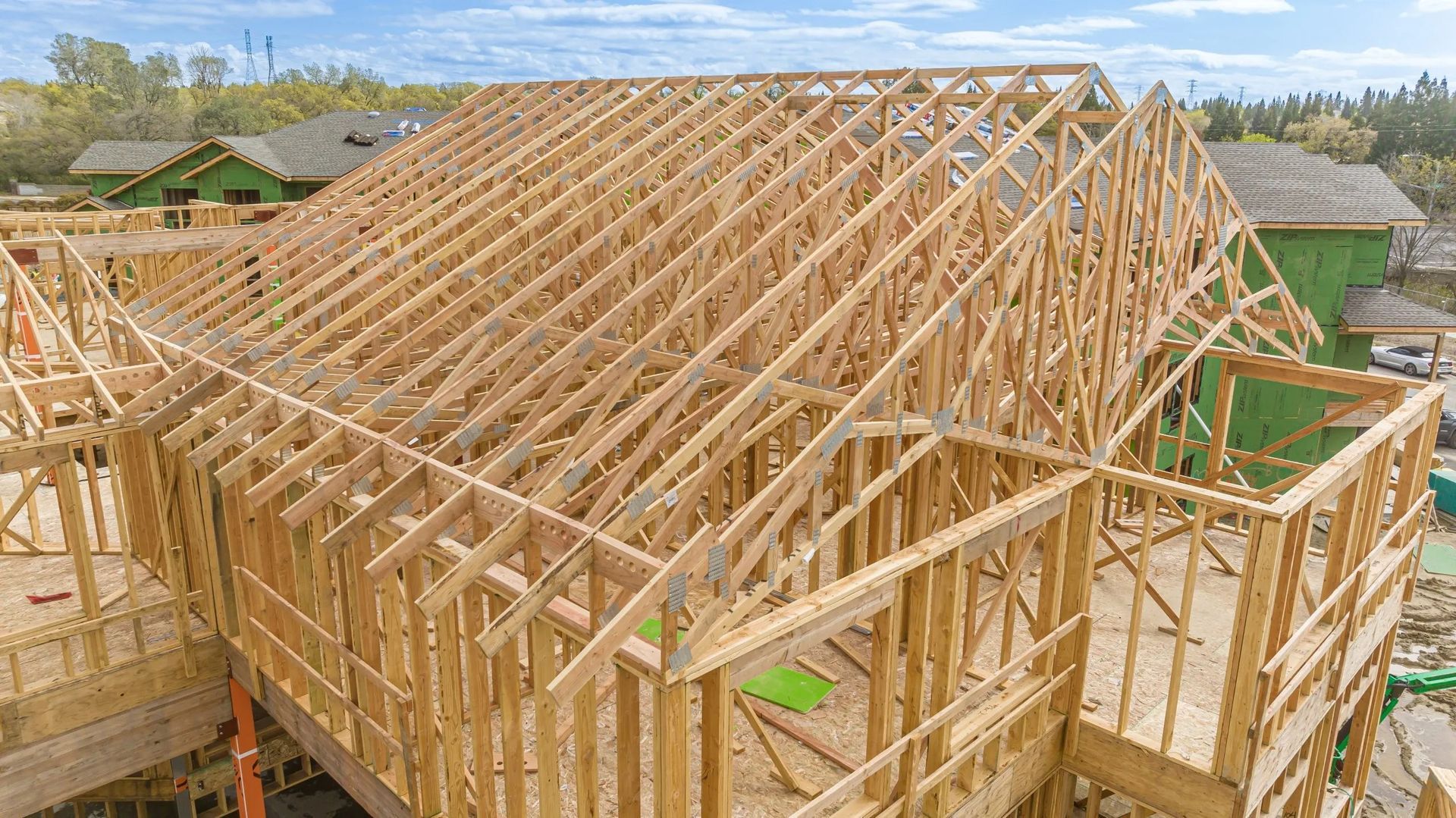 Wooden house frame under construction with roof trusses and exposed studs