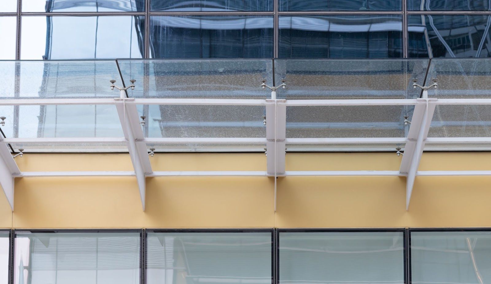 Transparent glass awning on modern building | France Fabric Awning