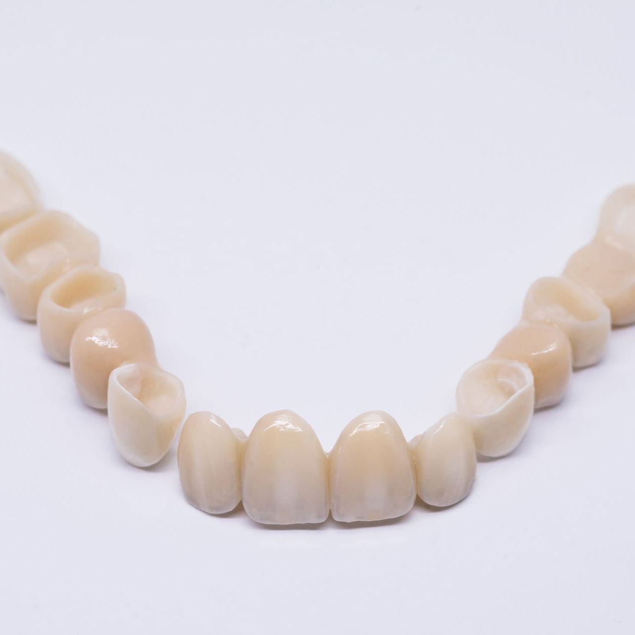 Tooth Relining — Port Noarlunga, SA — Natural Denture Clinic Upper dental arch with ceramic teeth on a white background.