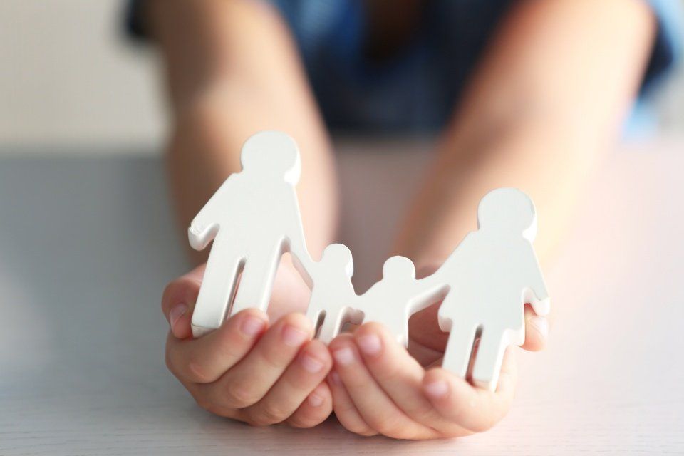 closeup of womans cupped hands showing paper man family