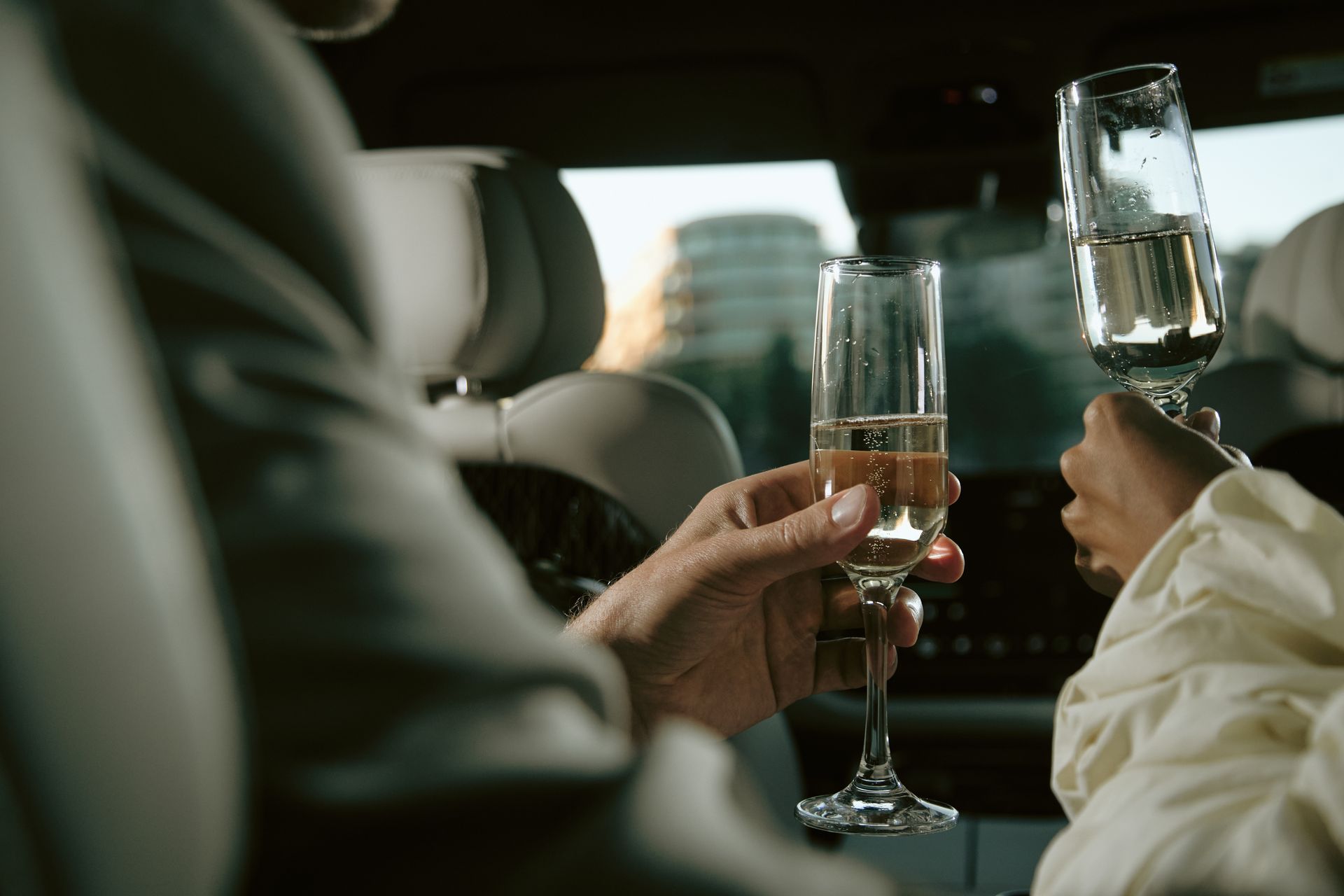Couple toasting with champagne in a luxury limo during a private wine tour celebration. Couple toasting with champagne in a luxury limo during a private wine tour celebration.