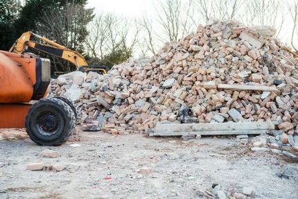 A pile of bricks and a bulldozer on a construction site.