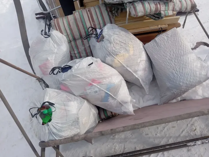 A bunch of bags are sitting on a sled in the snow