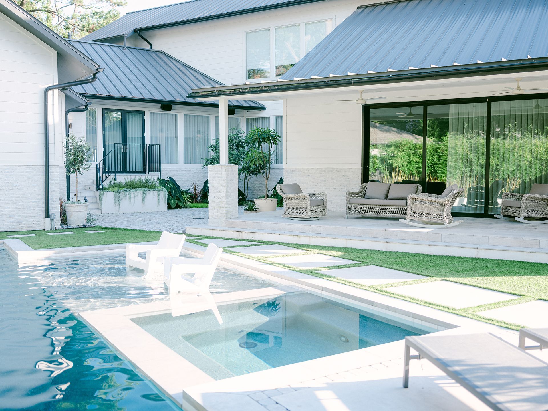 There is a large swimming pool in the backyard of a house.