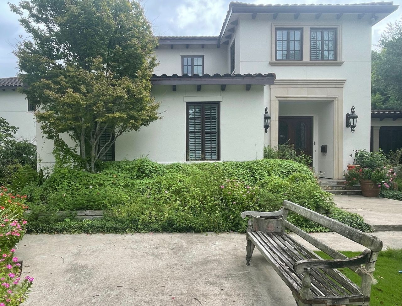 A white house with a wooden bench in front of it