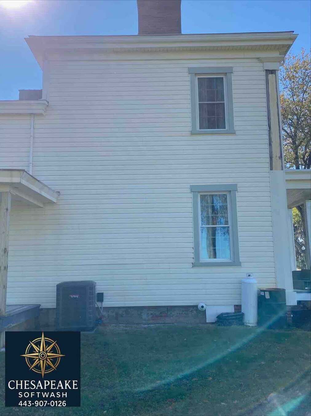 White two-story house exterior with small windows and a Chesapeake logo watermark in the lower left.