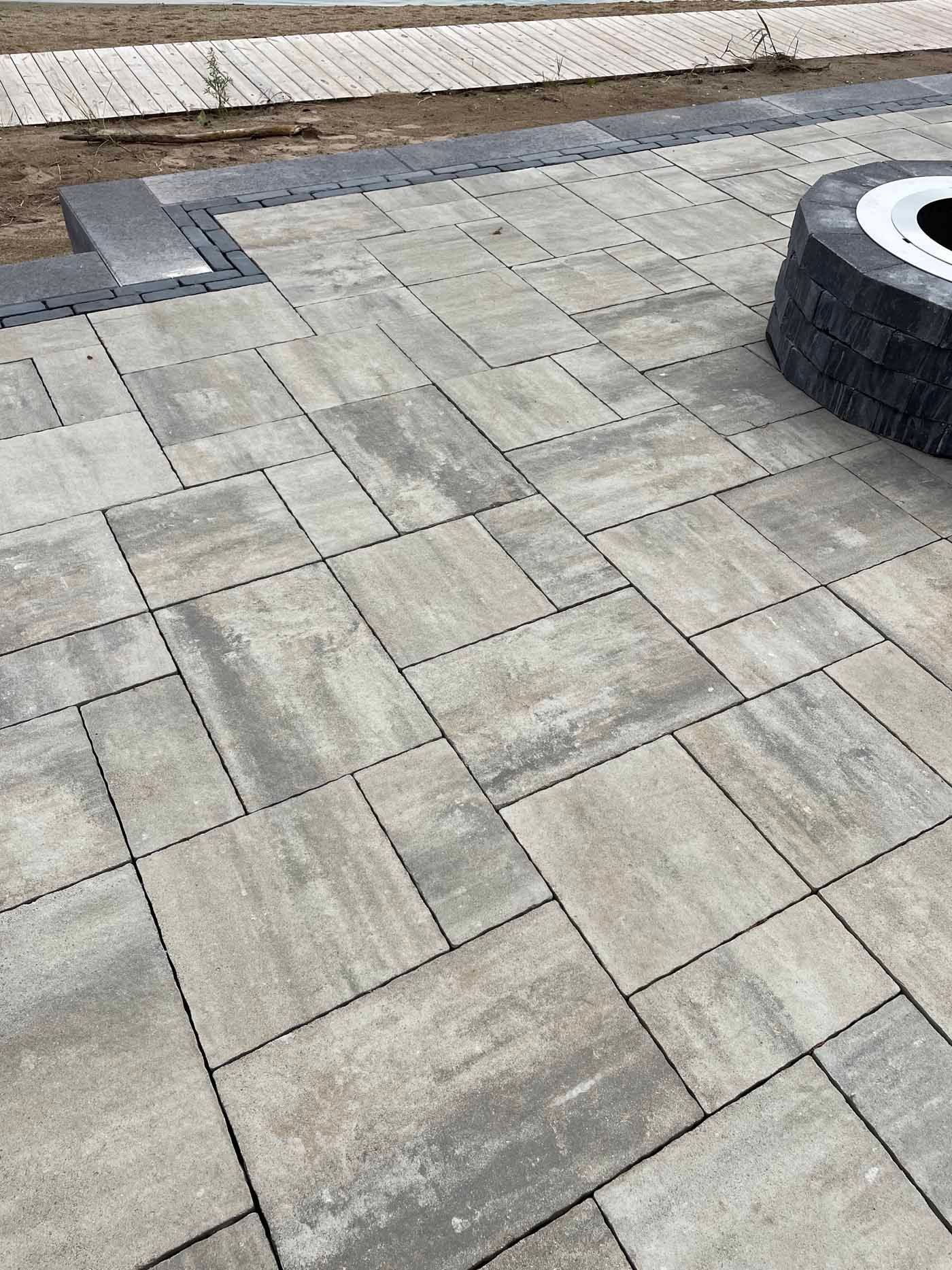 A patio with a fire pit in the middle of it.