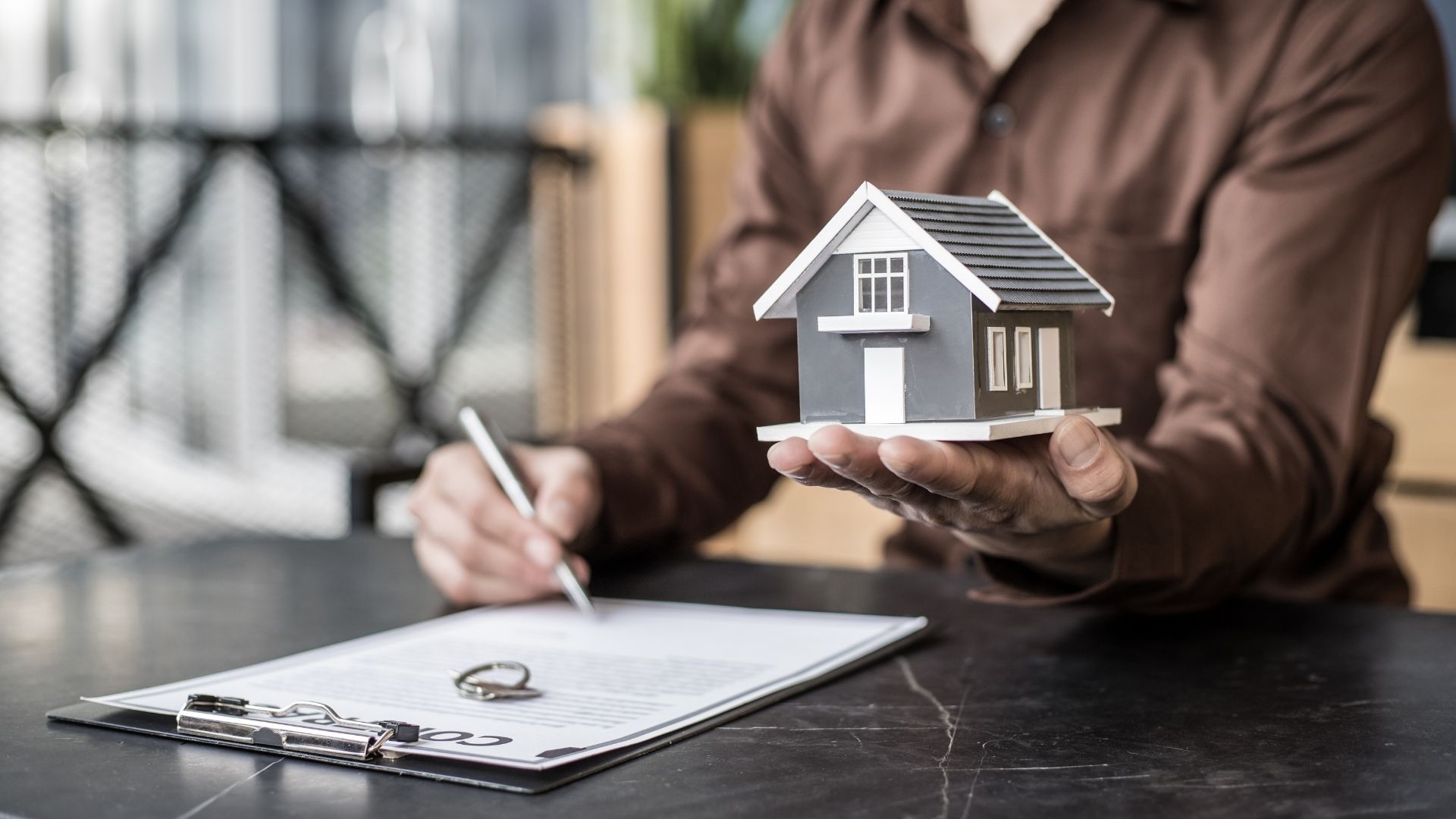 property manager holding a house and signing a contract
