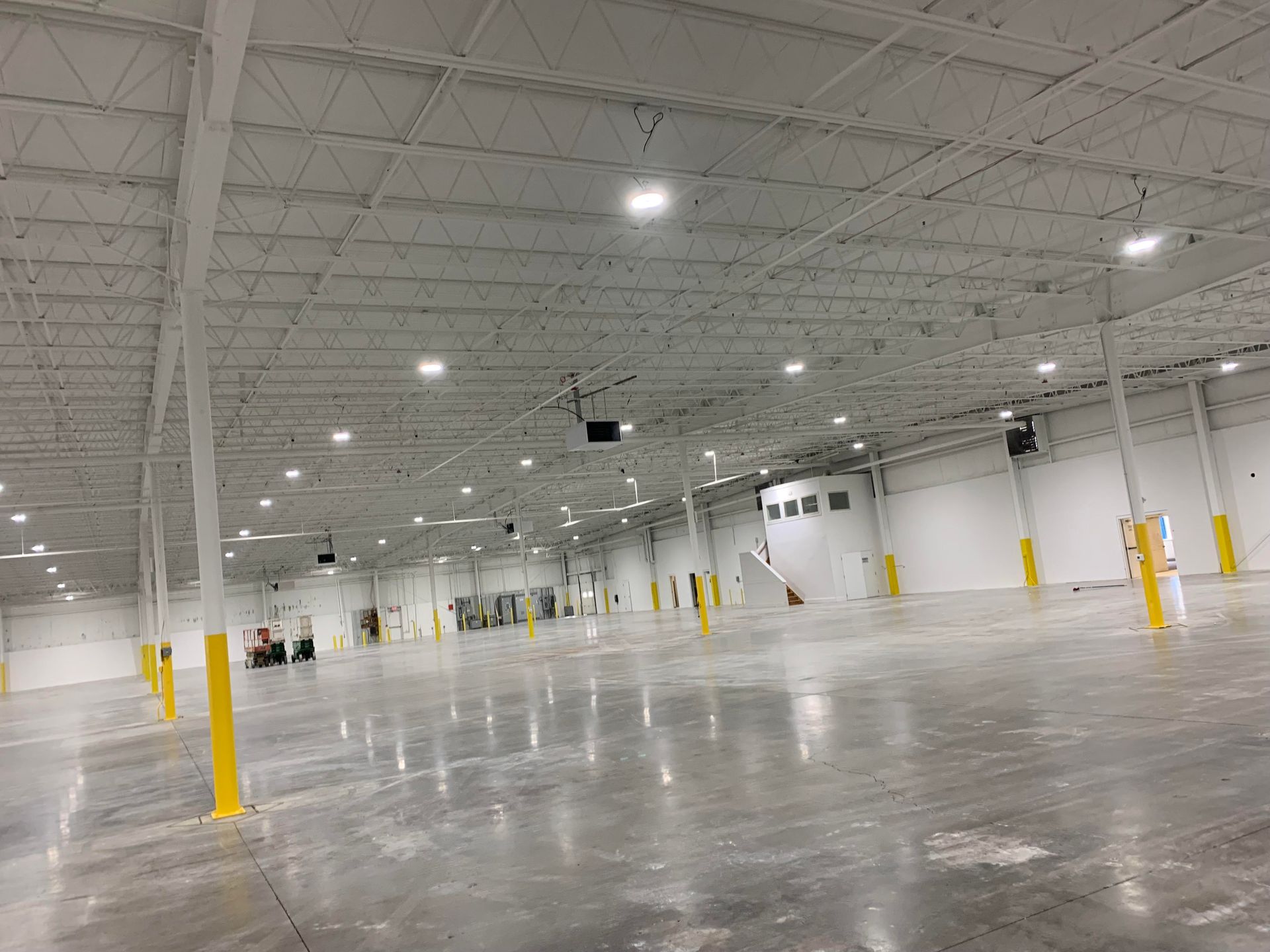 A large empty warehouse with white walls and a concrete floor.