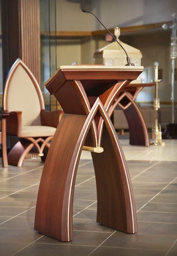 Modern wooden church pulpit with curved architectural design.