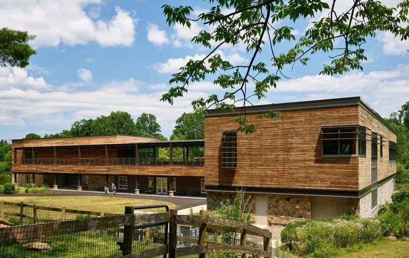 Modern wooden contemporary house with large windows in rural setting.