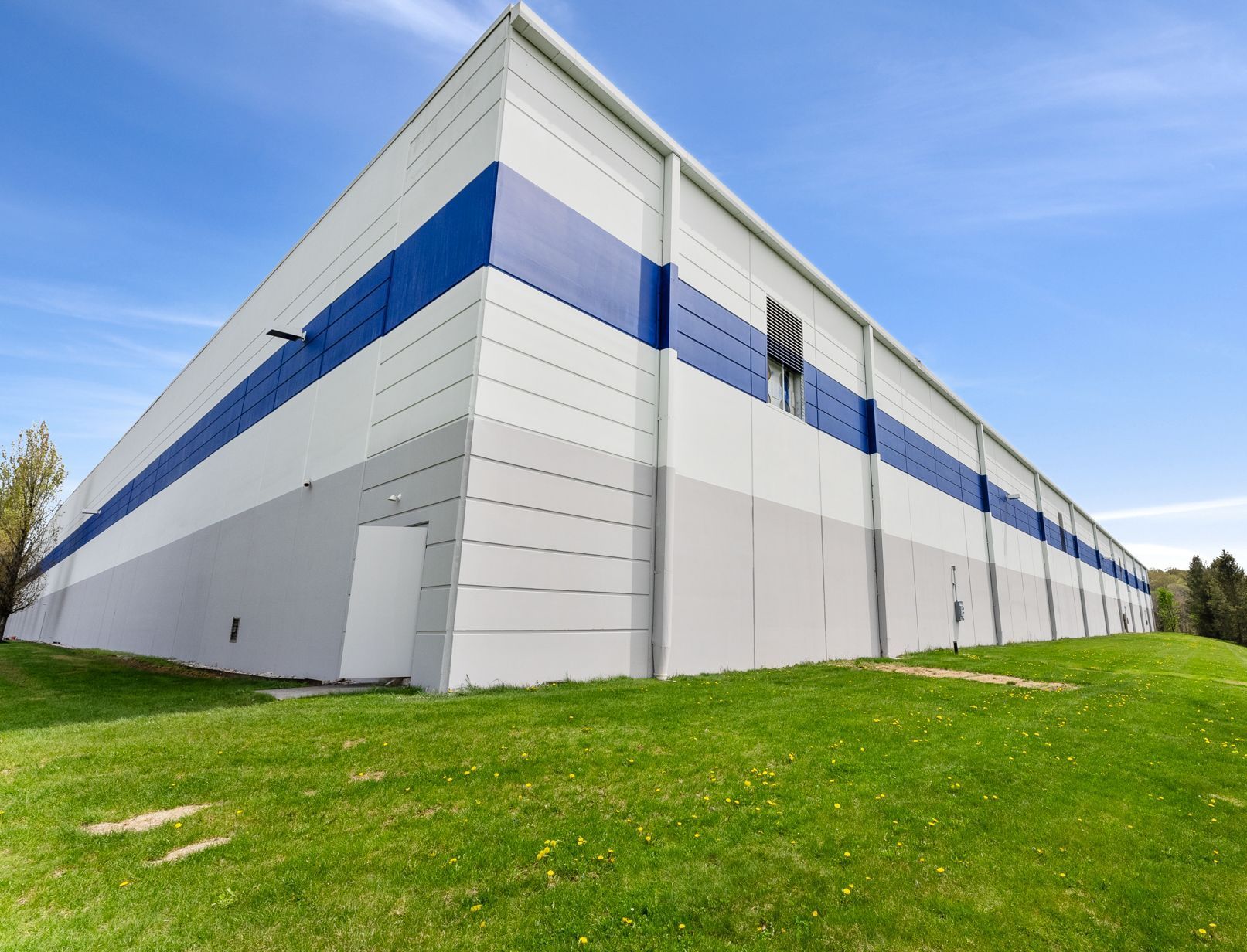 A large white building with blue stripes on the side