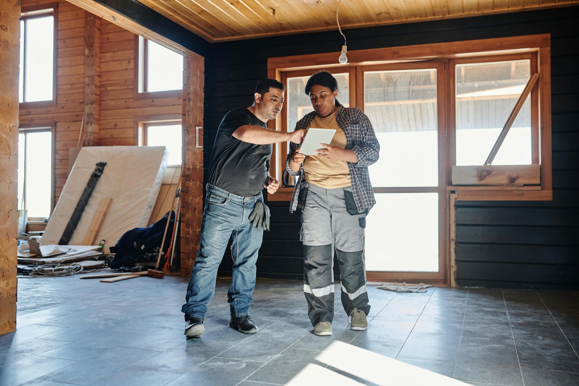 Commercial construction workers coordinating drywall installation during office renovation project.