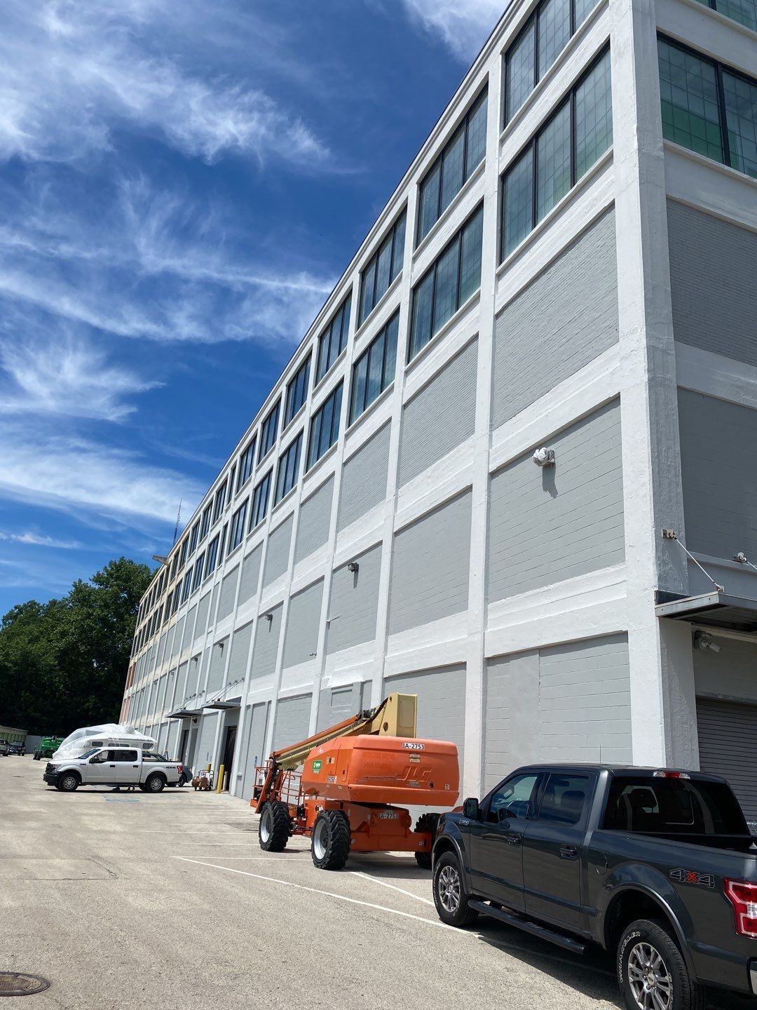A large building with a lot of windows and cars parked in front of it.
