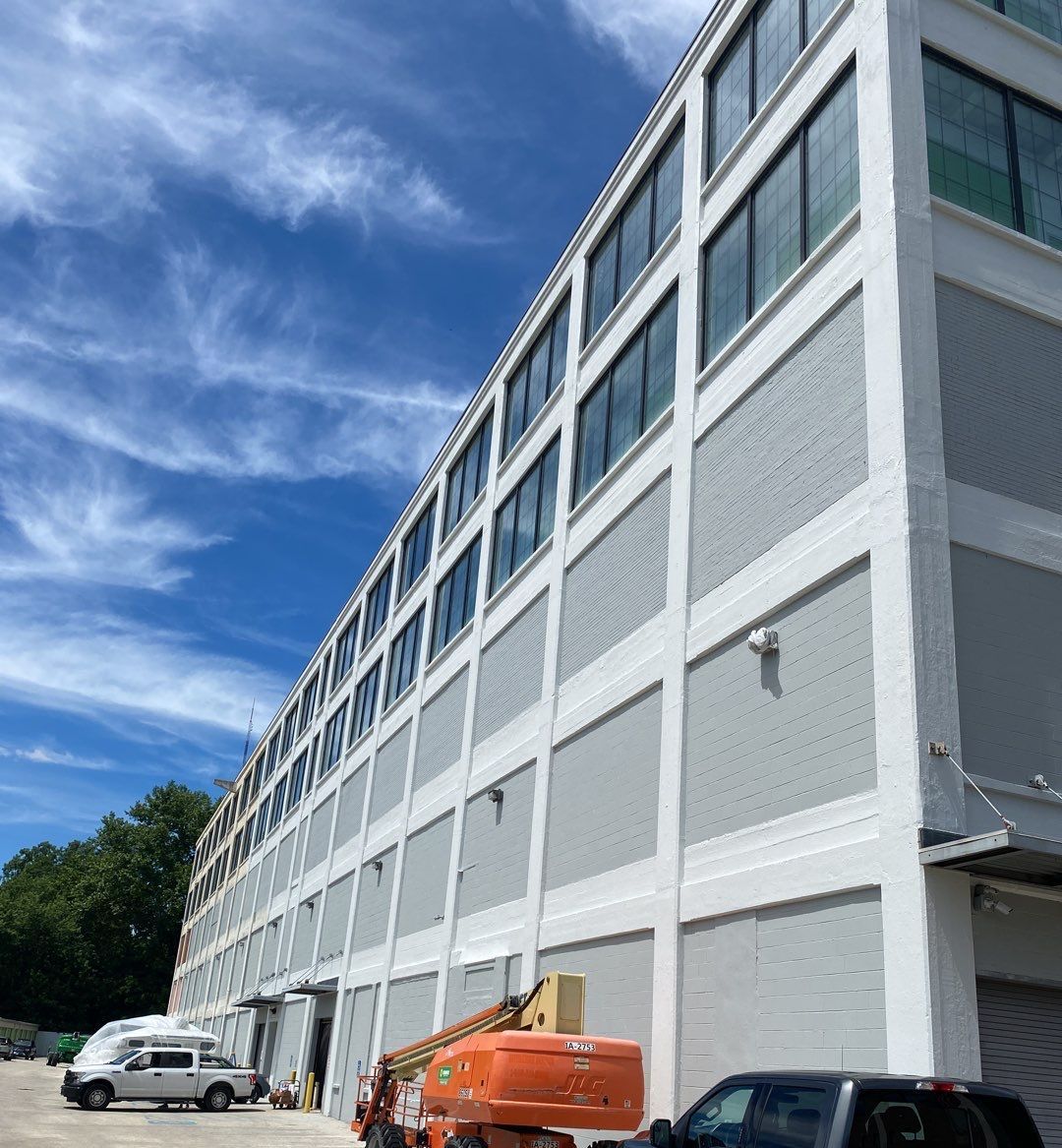 A large building with a lot of windows and a truck parked in front of it