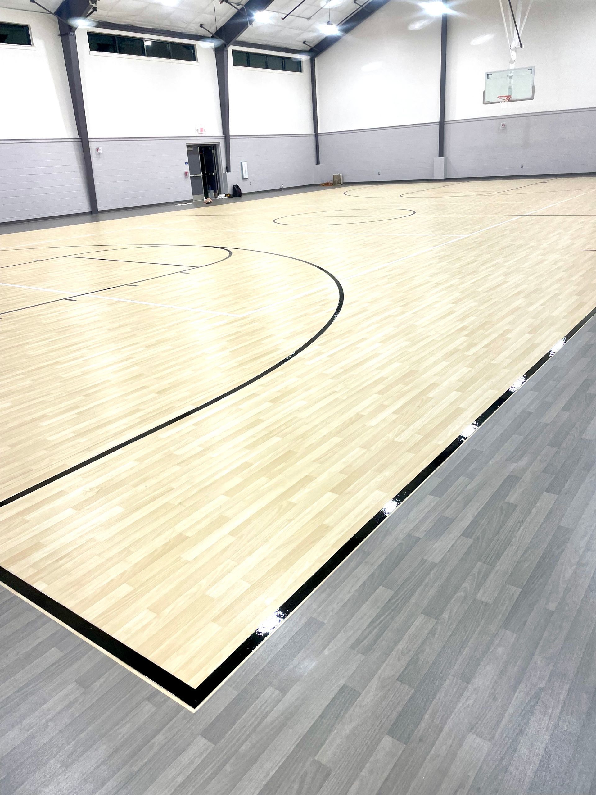 A large indoor basketball court with a wooden floor