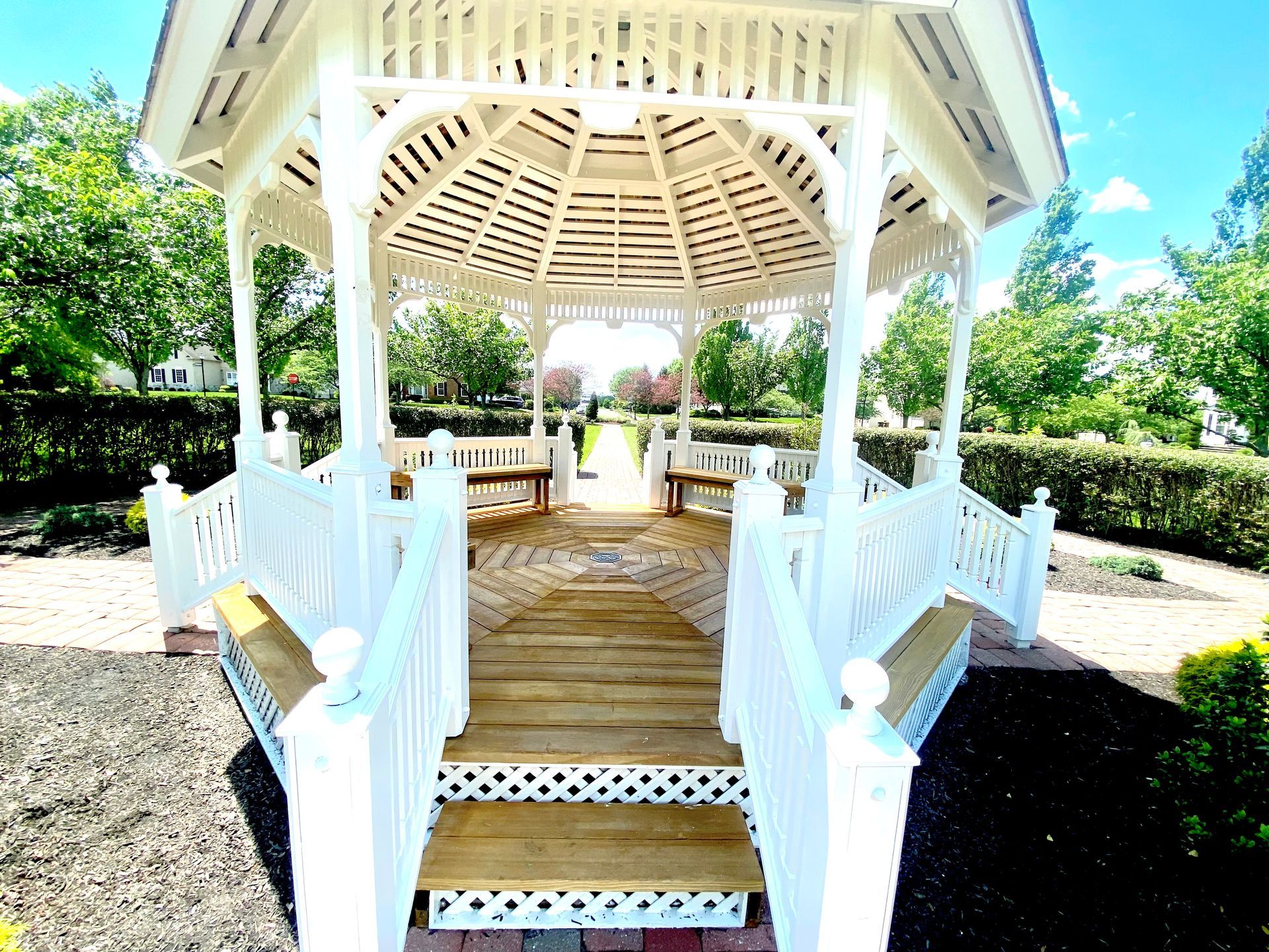 A white gazebo with stairs leading up to it