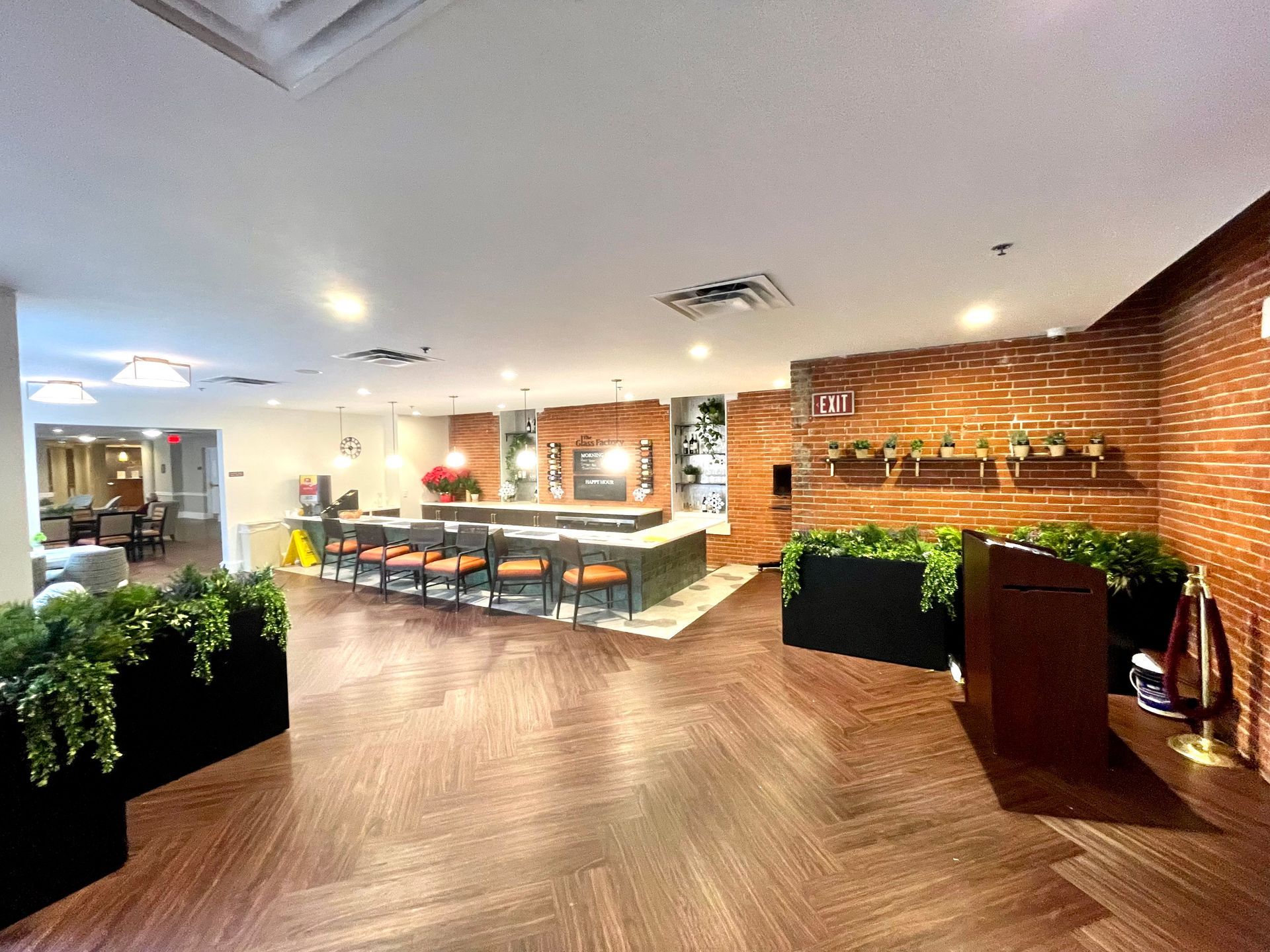 A large room with a wooden floor and a brick wall.