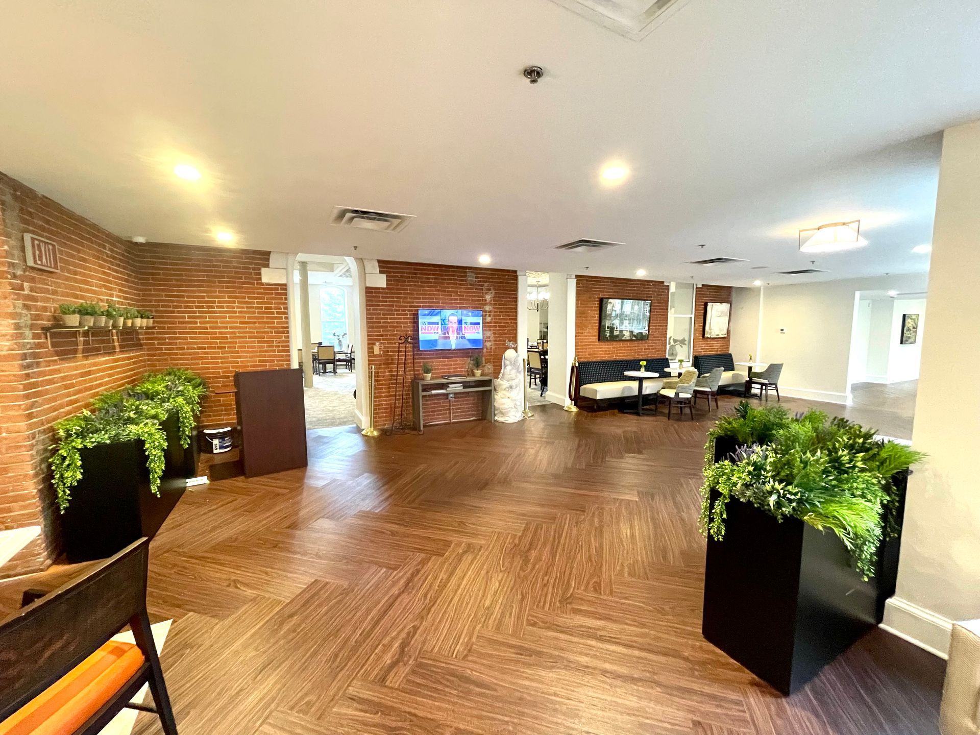 A large room with a wooden floor and a brick wall.