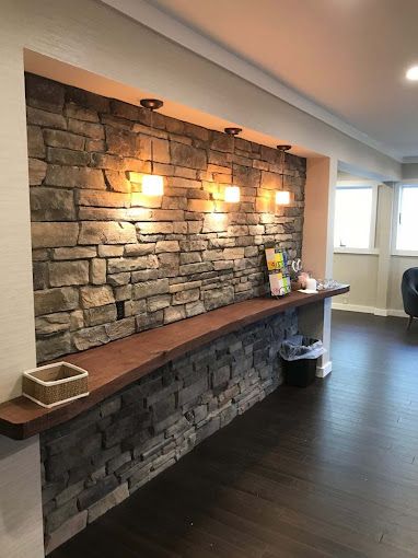 A room with a stone wall and a wooden counter.