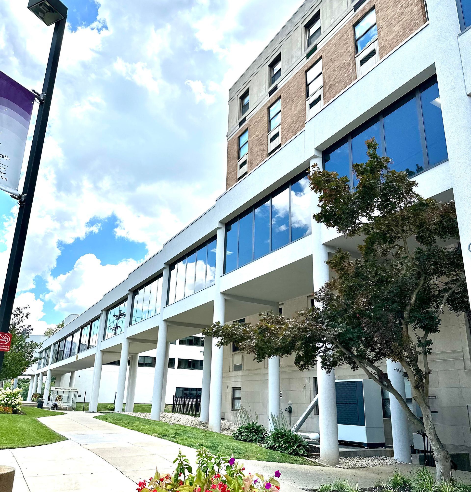 Modern mixed-use building with glass facade and white columns.