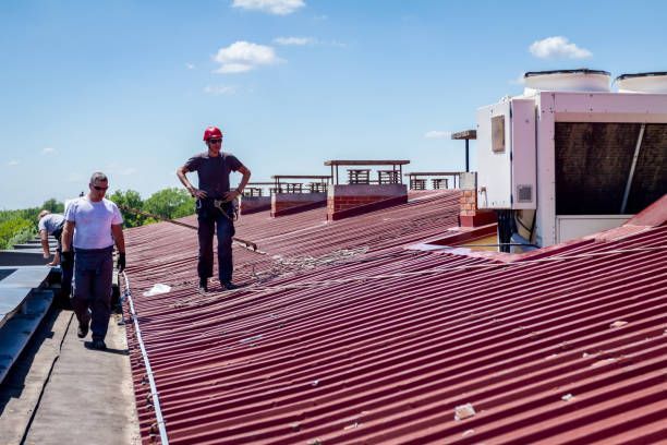 Commercial metal roof coating project with professional crew applying protective coating system.