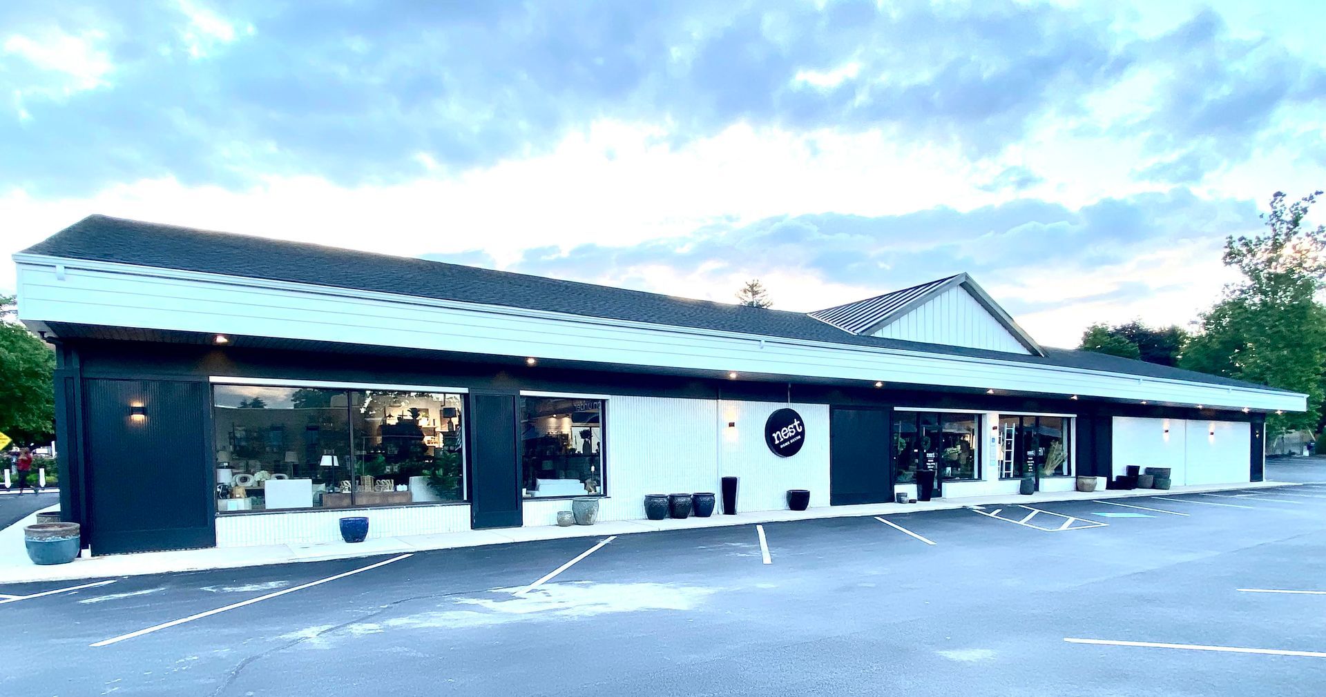 A large white and black building with a parking lot in front of it.