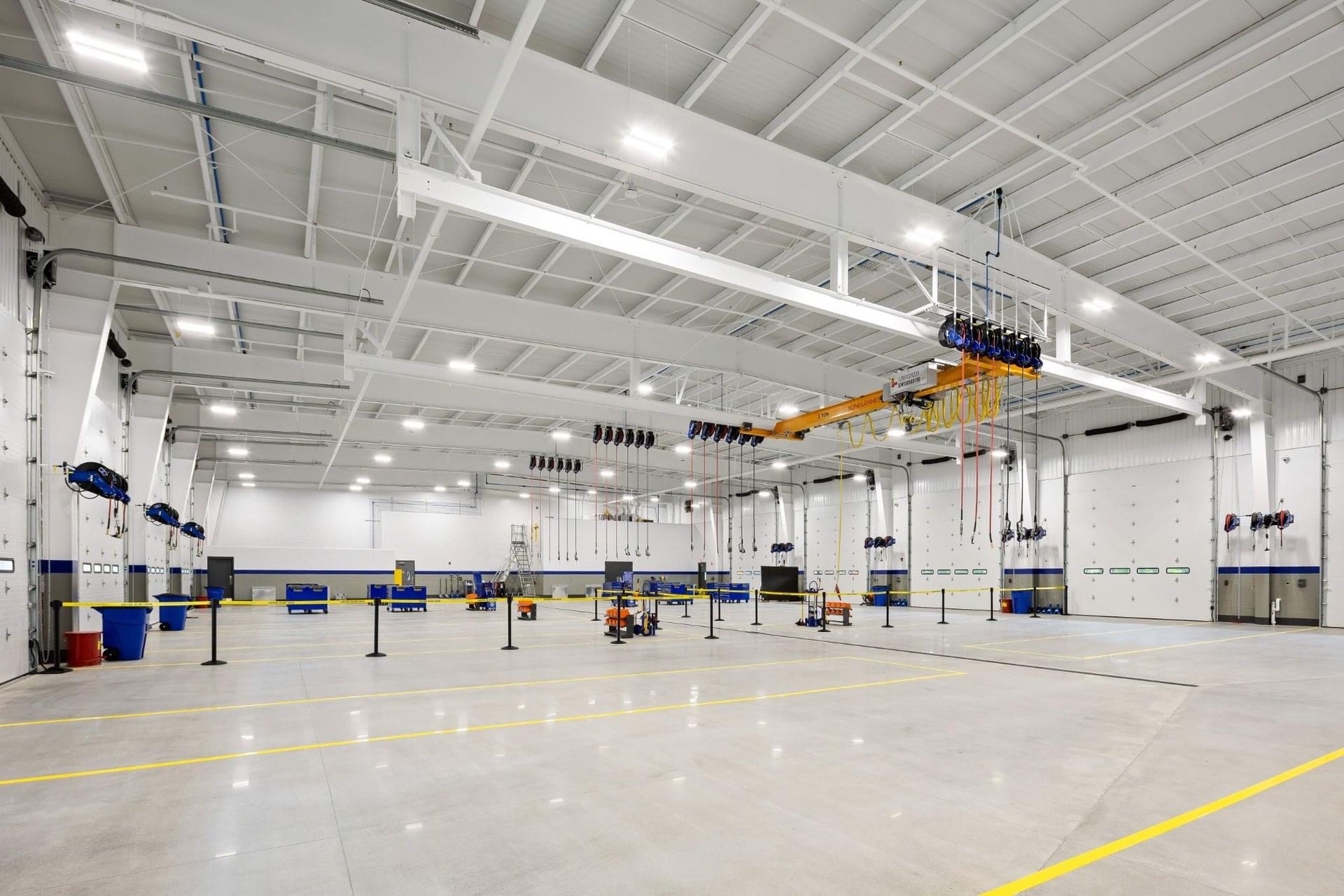A large empty warehouse with a crane hanging from the ceiling.