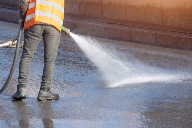 Commercial roof cleaning with pressure washing equipment before coating application preparation.