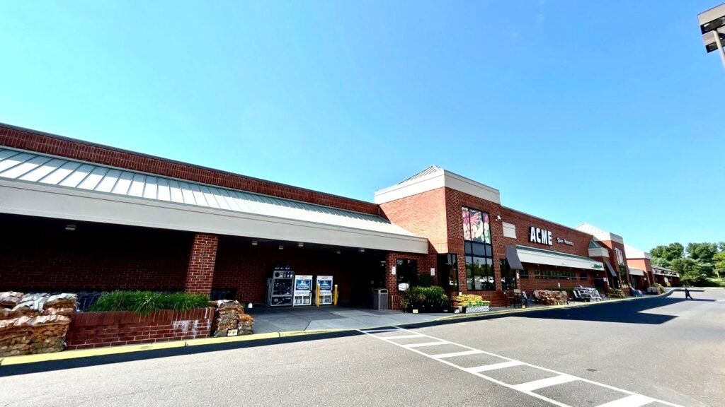 A large brick building with a parking lot in front of it.