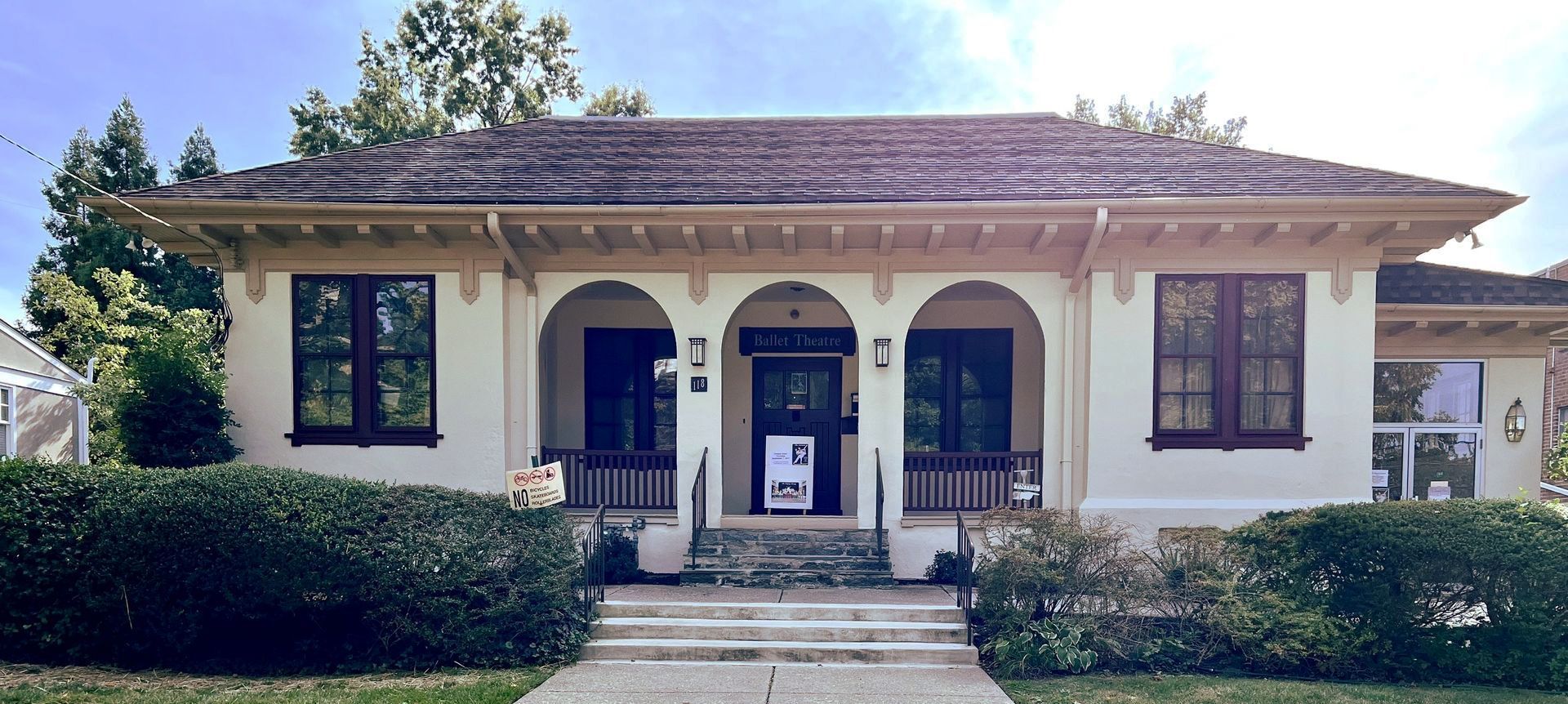 Single-story stucco bungalow with arched porch and hip roof