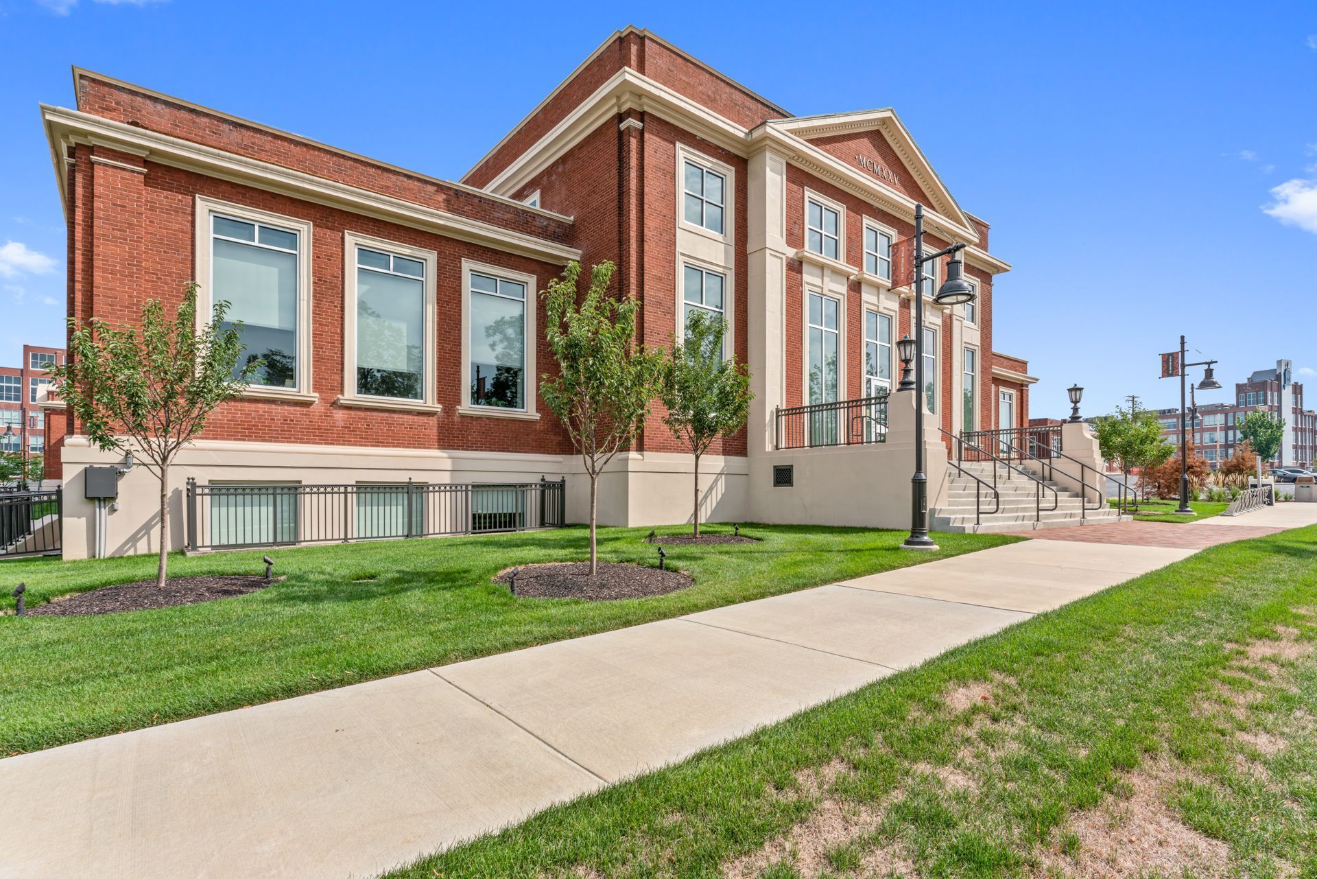 A large brick building with a sidewalk in front of it.