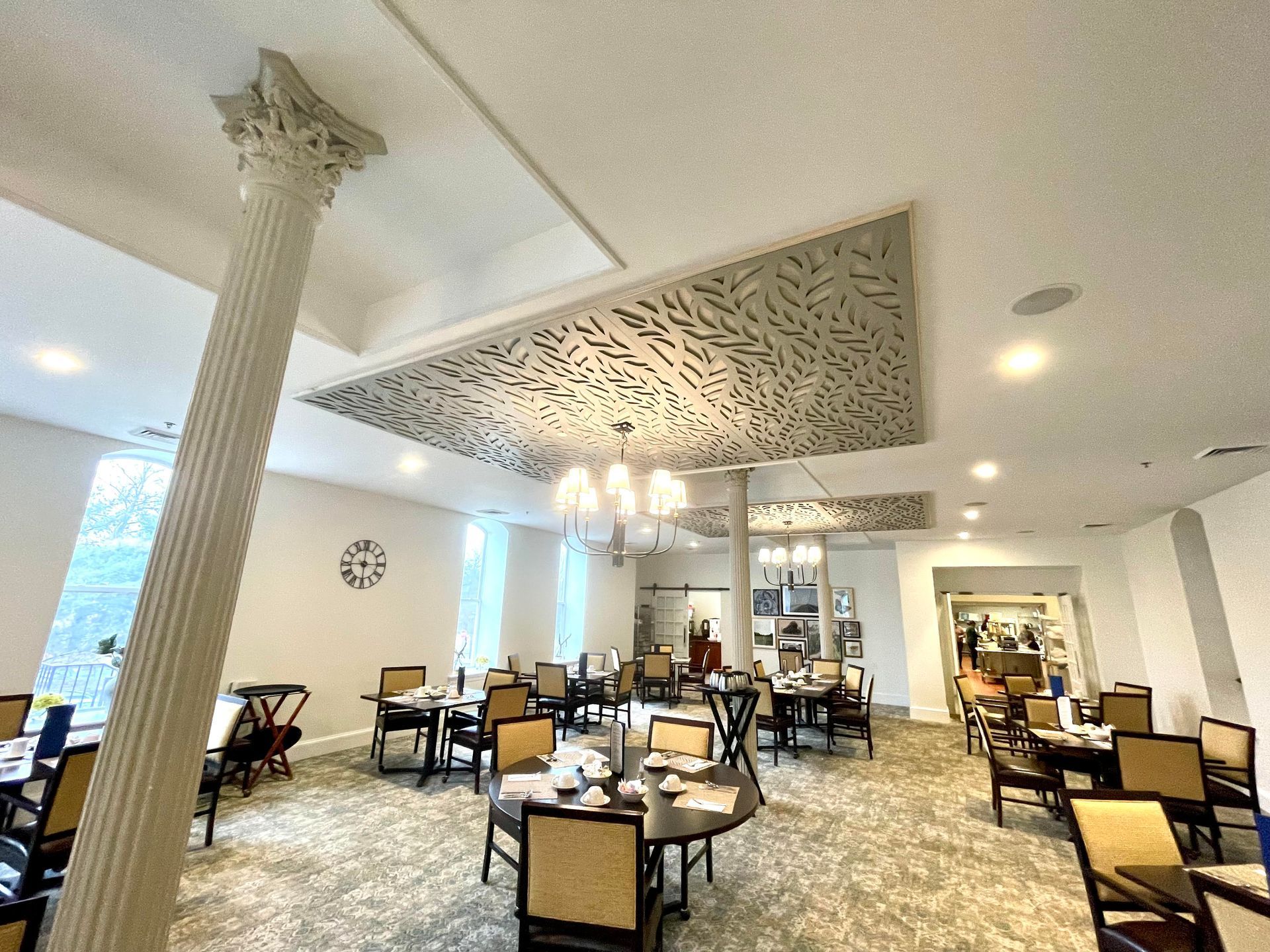 A large dining room with tables and chairs and a chandelier.